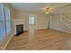 Spacious living room with a fireplace, wood floors, and large windows for plenty of natural light at 1036 Steelhorse Dr, Fuquay Varina, NC 27526