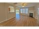 Large living room with wood floors, a fireplace, an archway to the kitchen, and a sliding glass door at 1036 Steelhorse Dr, Fuquay Varina, NC 27526