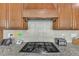 Kitchen features granite countertops, light backsplash and stainless steel stovetop and range hood at 1038 Branwell Dr, Durham, NC 27703