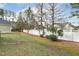 Well-maintained backyard features a white fence, green lawn, and mature trees at 104 Low Country Ct, Morrisville, NC 27560
