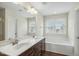Bright bathroom with double vanity, tub, and natural light from the window at 104 Low Country Ct, Morrisville, NC 27560
