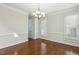 Elegant dining room featuring hardwood floors, a chandelier, and large window with natural light at 104 Low Country Ct, Morrisville, NC 27560