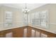 Bright dining room featuring hardwood floors, a chandelier, crown molding, and large windows at 104 Low Country Ct, Morrisville, NC 27560