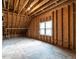 Unfinished attic space with exposed wooden beams and natural light at 107 Bella Casa Way, Clayton, NC 27527