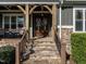 Inviting front entrance with stone steps and wood supports on a covered porch at 107 Bella Casa Way, Clayton, NC 27527