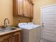 Bright laundry room features cabinetry, sink, modern washer and dryer, and lots of light at 107 Bella Casa Way, Clayton, NC 27527