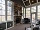 Cozy sunroom featuring a stone fireplace, large windows, and access to an outdoor deck at 107 Bella Casa Way, Clayton, NC 27527