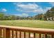 Beautiful backyard view overlooking large grass area with mature trees, as seen from wood deck at 108 Birdie Ct, Rocky Mount, NC 27804