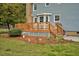 Backyard wooden deck with stairs, and lush landscaping including a mature tree and surrounding green grass at 108 Birdie Ct, Rocky Mount, NC 27804