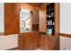 This bar area has wooden cabinets and shelves with a mirror and access to the kitchen at 108 Birdie Ct, Rocky Mount, NC 27804