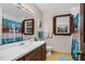 Bright bathroom with anchor-themed shower curtain, yellow tile floors, and a wood framed mirror at 108 Birdie Ct, Rocky Mount, NC 27804