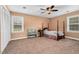 Cozy bedroom features carpet flooring, four-post bed, large window, and a ceiling fan with light fixture at 108 Birdie Ct, Rocky Mount, NC 27804