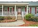 Charming front porch with brick stairs, white railing, and plants near the entrance at 108 Birdie Ct, Rocky Mount, NC 27804