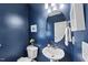 Stylish powder room with blue walls and a unique oval mirror at 111 Kim Bark Path, Garner, NC 27529