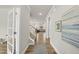 Inviting hallway with hardwood floors and neutral paint leads to a bright living space with a carpeted stairway at 111 Kim Bark Path, Garner, NC 27529