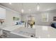 Modern kitchen with a farmhouse sink, quartz countertop, and views to the outdoor screened porch at 111 Kim Bark Path, Garner, NC 27529