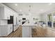 Bright kitchen boasts white cabinets, stainless appliances, and a large island with seating for casual dining at 111 Kim Bark Path, Garner, NC 27529