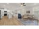Open living room featuring hardwood floors, modern furniture, and seamless flow into kitchen and breakfast nook at 111 Kim Bark Path, Garner, NC 27529
