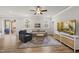 Cozy living room features hardwood floors, neutral paint, a ceiling fan, a comfortable sofa, and natural light at 111 Kim Bark Path, Garner, NC 27529