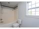 Bathroom featuring a bathtub/shower combo, toilet, and window at 114 Hudson Dr, Princeton, NC 27569