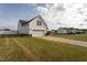 View of a detached garage with white siding, red shutters, and a concrete driveway on a grassy lot at 114 Hudson Dr, Princeton, NC 27569
