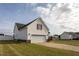View of a detached garage with white siding, red shutters, and a concrete driveway on a grassy lot at 114 Hudson Dr, Princeton, NC 27569