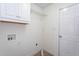 Bright laundry room with overhead cabinets, wire shelving, and tile flooring at 114 Hudson Dr, Princeton, NC 27569
