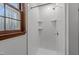 Bright white bathroom features a shower with built in shelving and a window at 11404 Leesville Rd, Raleigh, NC 27613