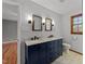 Bathroom featuring a double vanity with a marble countertop, dual mirrors, and tile floors at 11404 Leesville Rd, Raleigh, NC 27613