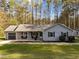 Charming single-story home with a gray exterior, well-manicured lawn, and a backdrop of mature trees at 11404 Leesville Rd, Raleigh, NC 27613
