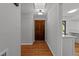 Hallway featuring hardwood floors that leads into the home with a solid wooden door at 11404 Leesville Rd, Raleigh, NC 27613