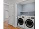Modern laundry room with blue walls, built-in shelving, and new front-load washer and dryer at 11404 Leesville Rd, Raleigh, NC 27613