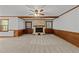The spacious living room boasts a fireplace, neutral carpet, and wood-paneled walls at 11404 Leesville Rd, Raleigh, NC 27613