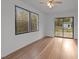 Bright living room with hardwood floors, a ceiling fan, and large windows offering plenty of natural light at 11404 Leesville Rd, Raleigh, NC 27613