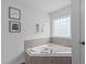 Inviting bathroom featuring tiled tub and decorative art prints at 120 Wellspring Dr, Holly Springs, NC 27540