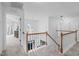 Upstairs landing area with wood railings, multiple pendant lights, and carpet at 120 Wellspring Dr, Holly Springs, NC 27540