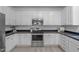 Bright kitchen featuring white cabinets, stainless steel appliances, dark countertops, and contemporary fixtures at 120 Wellspring Dr, Holly Springs, NC 27540