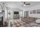 Comfortable living room featuring a fireplace, sofa, large windows, and ceiling fan at 120 Wellspring Dr, Holly Springs, NC 27540