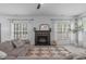 Bright living room featuring a fireplace, large windows, comfortable sofa, and stylish decor at 120 Wellspring Dr, Holly Springs, NC 27540
