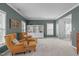 Cozy living room featuring armchairs, built-in shelving, neutral carpet, and ample natural light from the window at 120 Wellspring Dr, Holly Springs, NC 27540