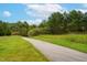 Scenic view of a walking path surrounded by lush greenery and trees on a sunny day at 120 Wellspring Dr, Holly Springs, NC 27540