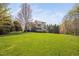 View of the back of this traditional home with a large lawn on a sunny day at 1204 Croydon Glen Ct, Cary, NC 27519