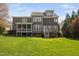 View of the back of this traditional home with a large lawn and screened in porch at 1204 Croydon Glen Ct, Cary, NC 27519