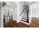 Spacious foyer featuring hardwood floors, staircase with dark wood handrail and open access to the home's layout at 1204 Croydon Glen Ct, Cary, NC 27519