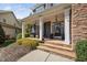 Welcoming front porch with seating and potted plants, inviting guests to this charming home with stone accents at 1204 Croydon Glen Ct, Cary, NC 27519