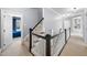 Well-lit hallway with staircase and dark wood railings, creating an inviting space at 1204 Croydon Glen Ct, Cary, NC 27519