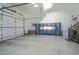 Clean garage with storage cabinets, epoxy floors, work space and stairs to upper level at 1229 Westerham Dr, Wake Forest, NC 27587