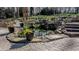 Outdoor waterfall feature and pond on brick patio lined with potted plants and mature trees at 1229 Westerham Dr, Wake Forest, NC 27587