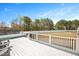 Back deck featuring a hot tub, gray Adirondack chairs and a fenced in yard surrounded by mature trees at 14 E Saddle Ct, Archer Lodge, NC 27527