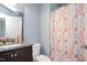 Half bathroom with granite countertop, dark wood vanity and pink and orange shower curtain at 14 E Saddle Ct, Archer Lodge, NC 27527